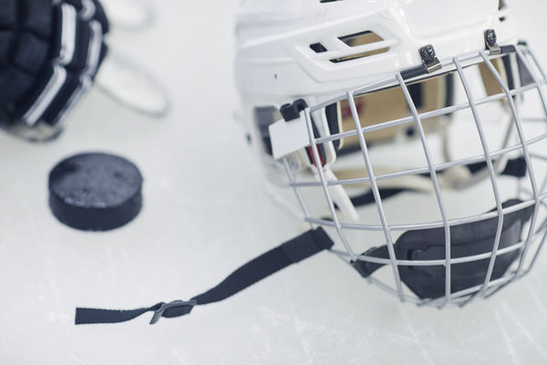 A hockey helmet, puck on the ice from an aerial view